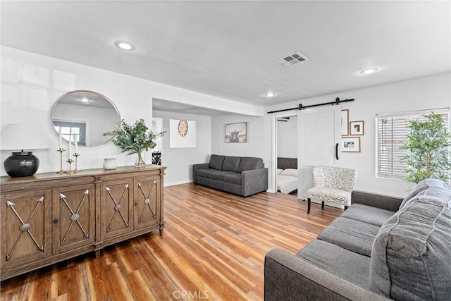 14508 S Corlett Ave, Compton, CA 90220 - living room with light wood-type flooring, recessed lighting, a barn door, and plenty of natural light