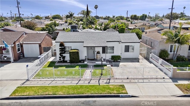 14508 S Corlett Ave, Compton, CA 90220 - view of front of house featuring concrete driveway, a residential view, a fenced front yard, stucco siding, and a shingled roof