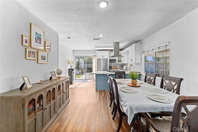 14508 S Corlett Ave, Compton, CA 90220 - dining area featuring a textured wall, a textured ceiling, and light wood-style floors