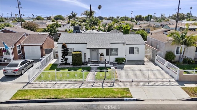 14508 S Corlett Ave, Compton, CA 90220 - view of front of property with driveway, a residential view, a shingled roof, a fenced front yard, and stucco siding