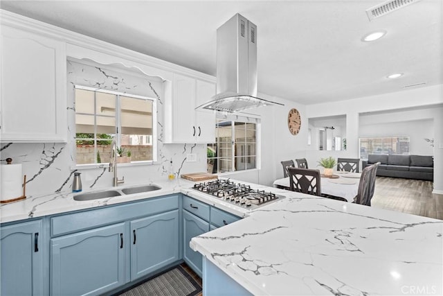 14508 S Corlett Ave, Compton, CA 90220 - kitchen featuring island range hood, stainless steel gas stovetop, white cabinetry, blue cabinetry, and light stone counters