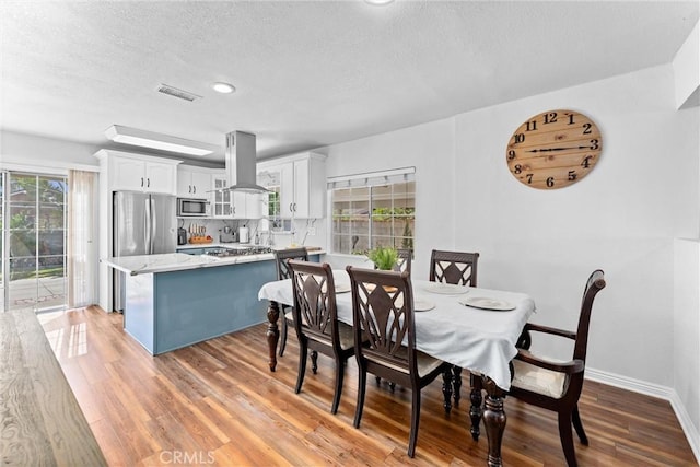14508 S Corlett Ave, Compton, CA 90220 - dining area featuring light wood-style floors, plenty of natural light, a textured ceiling, and recessed lighting