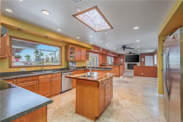 2935 Athel Dr, Hacienda Heights, CA 91745 - kitchen featuring appliances with stainless steel finishes, a center island with sink, recessed lighting, a skylight, and dark countertops