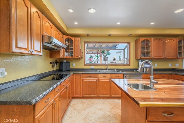 2935 Athel Dr, Hacienda Heights, CA 91745 - kitchen featuring under cabinet range hood, black electric cooktop, butcher block countertops, glass insert cabinets, and recessed lighting