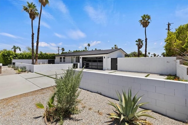 2002 N Whitewater Club Dr N, Palm Springs, CA 92262 - view of front facade featuring a fenced front yard, concrete driveway, and an attached garage