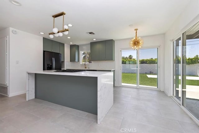 2002 N Whitewater Club Dr N, Palm Springs, CA 92262 - kitchen featuring black fridge, light countertops, gray cabinets, hanging light fixtures, and recessed lighting