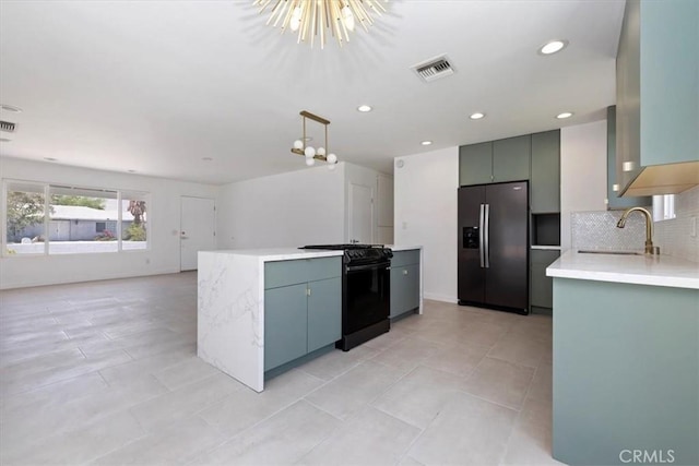 2002 N Whitewater Club Dr N, Palm Springs, CA 92262 - kitchen featuring fridge with ice dispenser, black range, light countertops, open floor plan, and tasteful backsplash