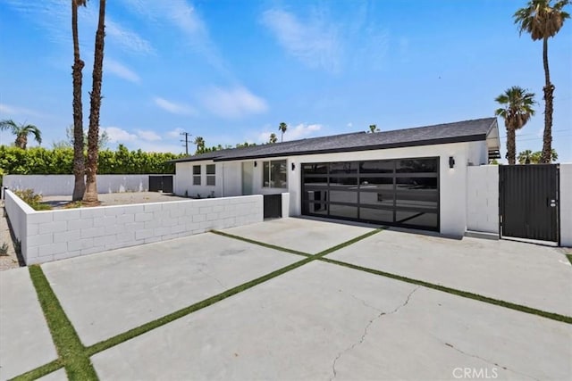 2002 N Whitewater Club Dr N, Palm Springs, CA 92262 - view of front of home with concrete driveway, an attached garage, and a gate