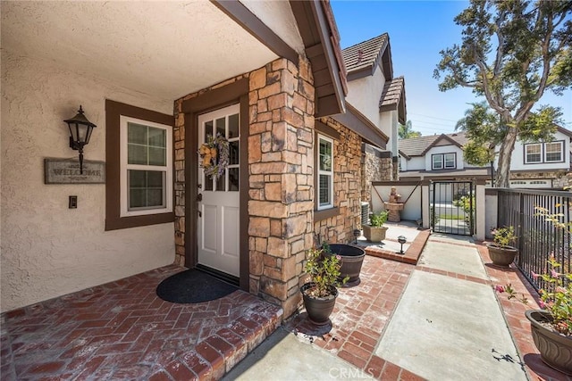 6171 E Morningview Dr, Anaheim, CA 92807 - doorway to property featuring stucco siding, stone siding, and a gate