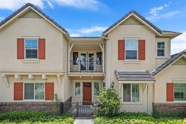 18 Zabila St, Rancho Mission Viejo, CA 92694 - view of property featuring brick siding, a balcony, a fenced front yard, and stucco siding