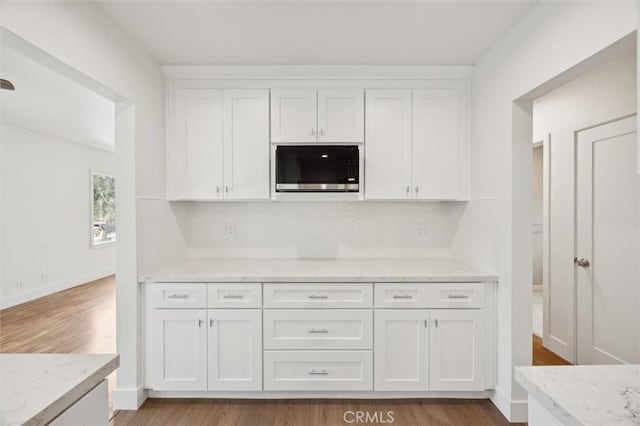 2141 Sierra Way, San Luis Obispo, CA 93401 - kitchen with white cabinetry, light wood finished floors, decorative backsplash, and light stone counters