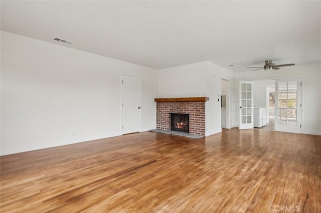 2141 Sierra Way, San Luis Obispo, CA 93401 - unfurnished living room with light wood-style floors, a brick fireplace, a ceiling fan, and french doors
