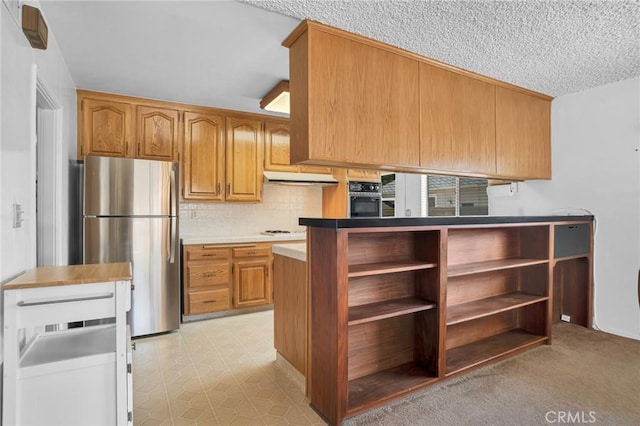18944 Prairie St, Northridge, CA 91324 - kitchen featuring freestanding refrigerator, oven, under cabinet range hood, decorative backsplash, and brown cabinets