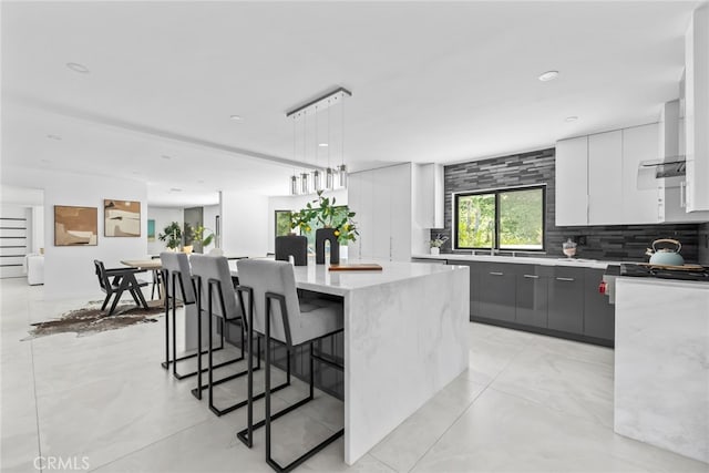 20101 Greenbriar Dr, Tarzana, CA 91356 - kitchen with modern cabinets, a kitchen island, backsplash, a kitchen bar, and recessed lighting