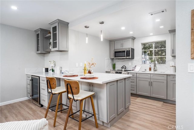 3401 E Wilton St Unit 204, Long Beach, CA 90804 - kitchen with gray cabinetry, wine cooler, stainless steel microwave, a peninsula, and recessed lighting