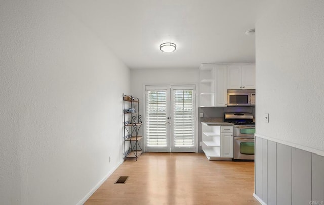 3168 Florine Dr, Lemon Grove, CA 91945 - kitchen with appliances with stainless steel finishes, open shelves, white cabinets, and light wood-style flooring