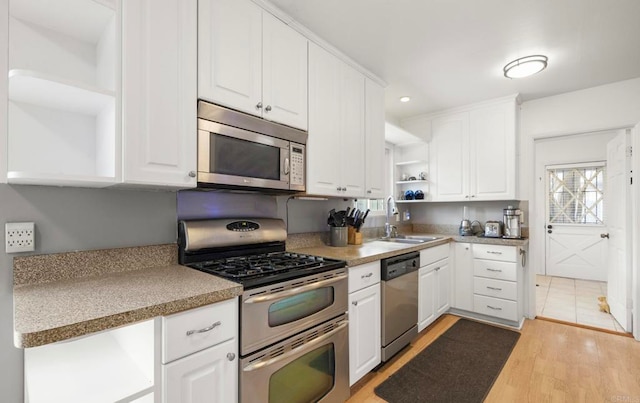 3168 Florine Dr, Lemon Grove, CA 91945 - kitchen with open shelves, appliances with stainless steel finishes, white cabinets, light wood-style flooring, and light countertops