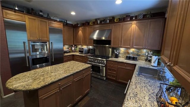 28107 Graciosa St, Valencia, CA 91355 - kitchen with range hood, high quality appliances, tasteful backsplash, light stone counters, and a kitchen island