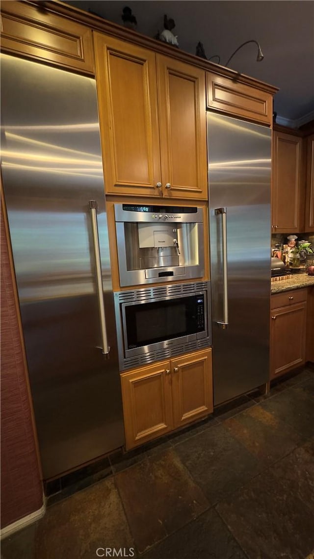 28107 Graciosa St, Valencia, CA 91355 - kitchen featuring built in appliances, dark stone finish flooring, and brown cabinets
