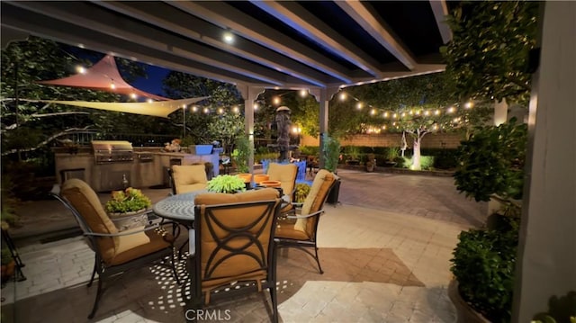 28107 Graciosa St, Valencia, CA 91355 - patio at night with exterior kitchen, a patio, a fenced backyard, and outdoor dining area