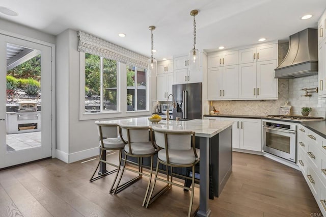 5414 Foxtail Loop, Carlsbad, CA 92010 - kitchen with appliances with stainless steel finishes, custom exhaust hood, dark wood finished floors, backsplash, and white cabinets