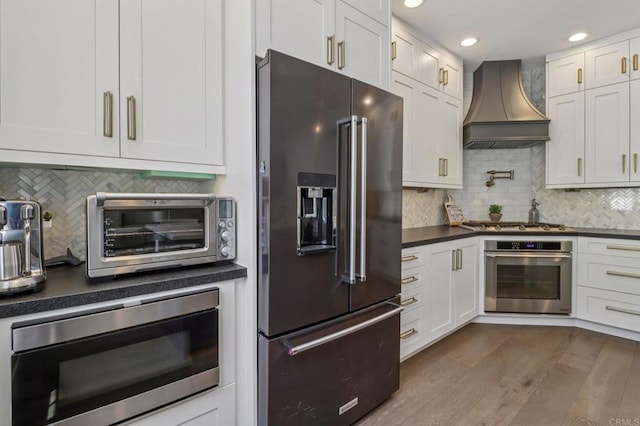 5414 Foxtail Loop, Carlsbad, CA 92010 - kitchen featuring appliances with stainless steel finishes, premium range hood, dark countertops, tasteful backsplash, and recessed lighting