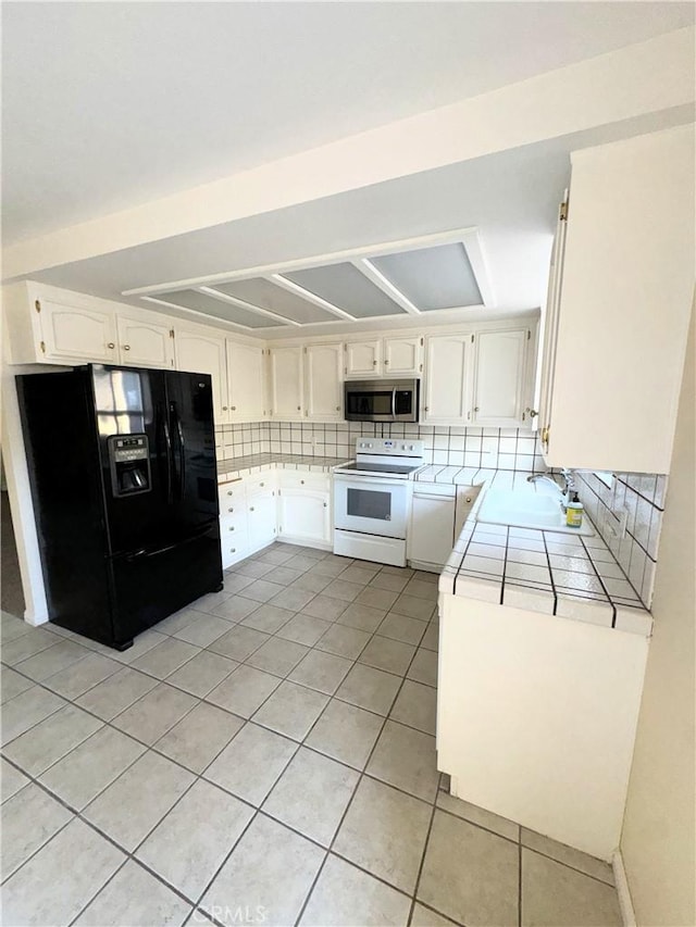 1107 Grieb Dr, Arroyo Grande, CA 93420 - kitchen with white electric range oven, black refrigerator with ice dispenser, stainless steel microwave, tile counters, and light tile patterned flooring