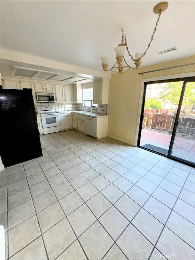 1107 Grieb Dr, Arroyo Grande, CA 93420 - kitchen with white appliances, light countertops, a chandelier, backsplash, and light tile patterned floors