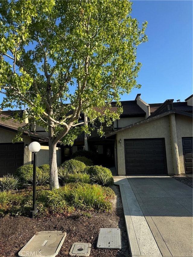 1107 Grieb Dr, Arroyo Grande, CA 93420 - view of property hidden behind natural elements featuring stucco siding, driveway, and a garage