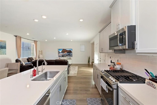 2275 Melogold Way, Corona, CA 92883 - kitchen with appliances with stainless steel finishes, open floor plan, light countertops, recessed lighting, and backsplash