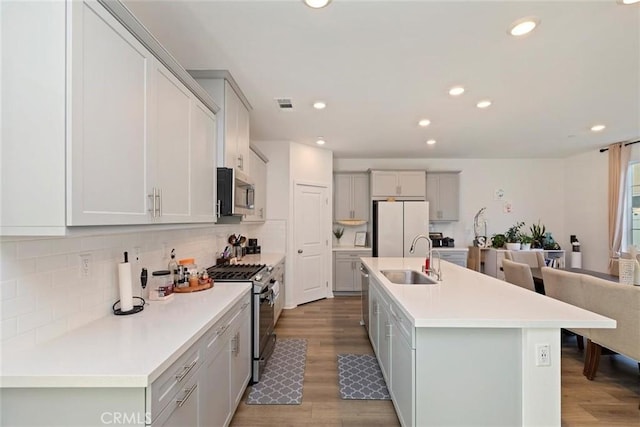 2275 Melogold Way, Corona, CA 92883 - kitchen featuring appliances with stainless steel finishes, wood finished floors, tasteful backsplash, recessed lighting, and light countertops