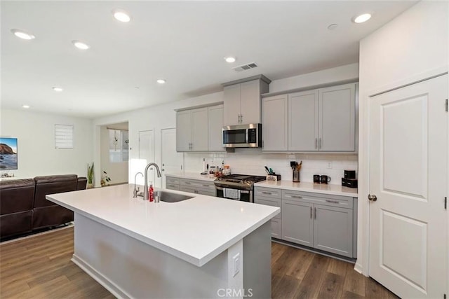 2275 Melogold Way, Corona, CA 92883 - kitchen with gray cabinets, stainless steel appliances, dark wood-style flooring, light countertops, and tasteful backsplash