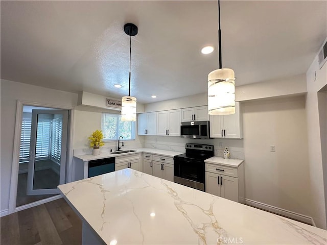 29041 Desert Hills Rd, Menifee, CA 92586 - kitchen featuring appliances with stainless steel finishes, light stone counters, dark wood finished floors, pendant lighting, and recessed lighting