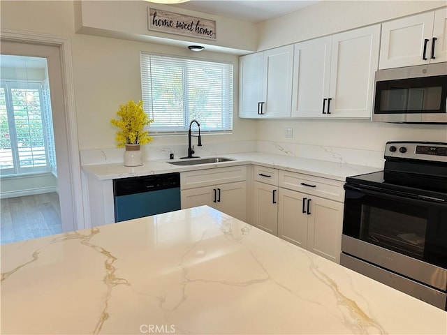 29041 Desert Hills Rd, Menifee, CA 92586 - kitchen featuring appliances with stainless steel finishes, white cabinets, light stone counters, and wood finished floors