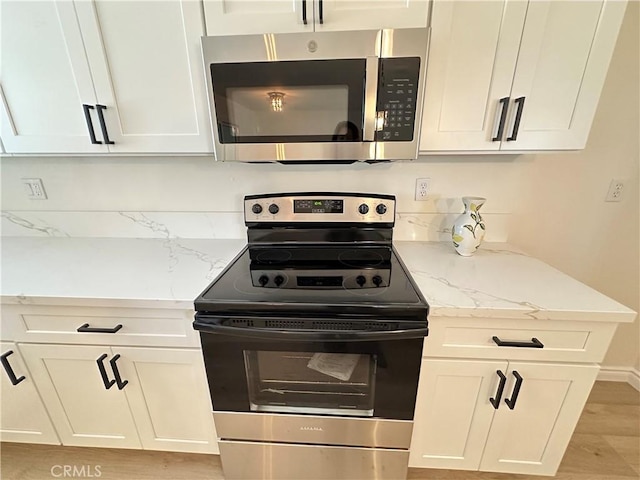 29041 Desert Hills Rd, Menifee, CA 92586 - kitchen with stainless steel appliances, white cabinets, light wood-type flooring, and light stone countertops