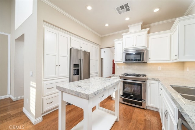 6001 Via De Mansion, La Verne, CA 91750 - kitchen with appliances with stainless steel finishes, white cabinetry, backsplash, light wood finished floors, and crown molding