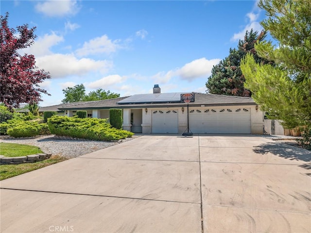 7556 Glider Ave, Hesperia, CA 92345 - ranch-style house featuring a garage, concrete driveway, solar panels, a chimney, and stucco siding