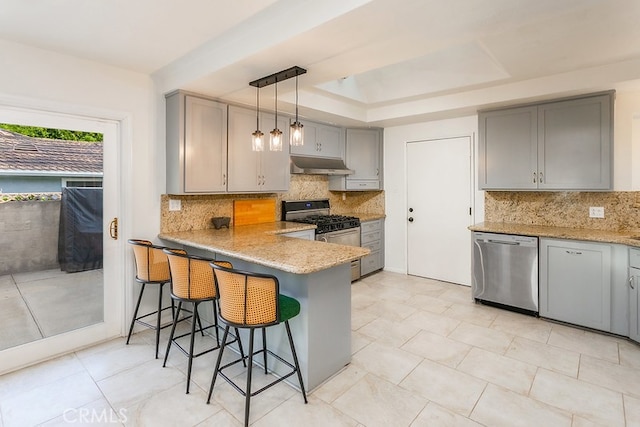 8398 Shoup Ave, West Hills, CA 91304 - kitchen with stainless steel appliances, gray cabinetry, under cabinet range hood, a breakfast bar area, and backsplash