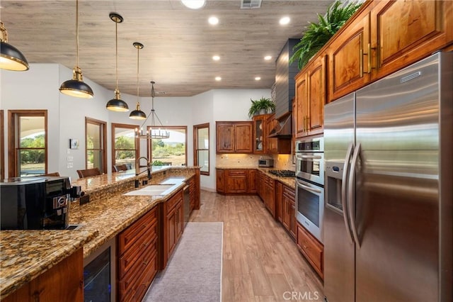 54774 Bautista Rd, Anza, CA 92539 - kitchen with stainless steel appliances, brown cabinetry, light wood finished floors, beverage cooler, and dark stone counters