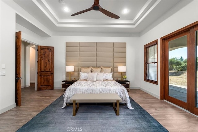 54774 Bautista Rd, Anza, CA 92539 - bedroom with a tray ceiling, wood finished floors, access to exterior, arched walkways, and a ceiling fan