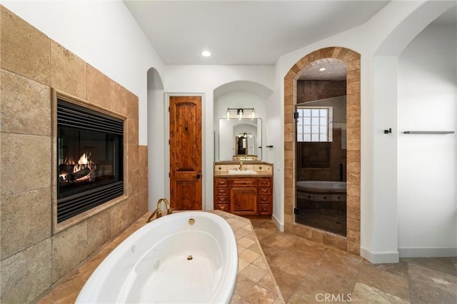 54774 Bautista Rd, Anza, CA 92539 - bathroom with a fireplace, vanity, a tub with jets, and recessed lighting