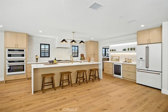 3756 Goodland Ave, Studio City, CA 91604 - kitchen with white appliances, light brown cabinetry, beverage cooler, tasteful backsplash, and recessed lighting