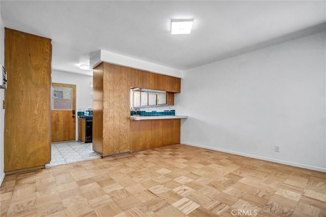 10422 Gilbert St, Anaheim, CA 92804 - kitchen with brown cabinets, light countertops, and a peninsula