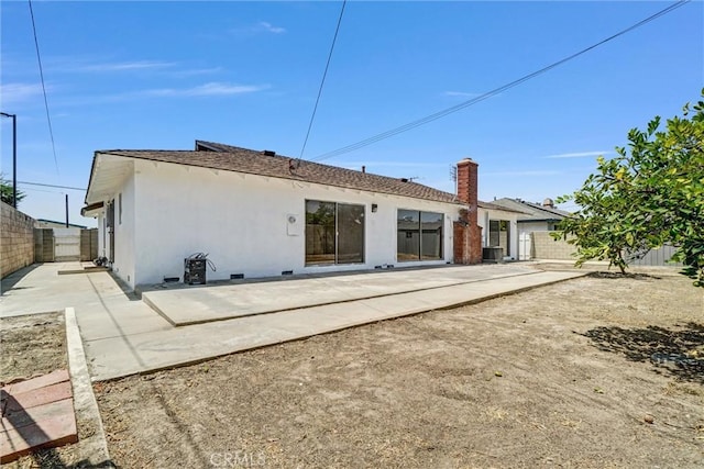 10422 Gilbert St, Anaheim, CA 92804 - back of property with a fenced backyard, a patio area, stucco siding, and a chimney