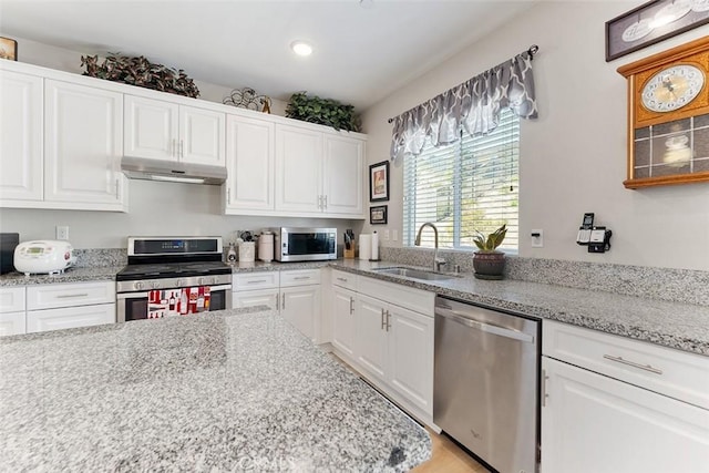 4073 Tamarind Rdg, Lake Elsinore, CA 92530 - kitchen featuring stainless steel appliances, under cabinet range hood, white cabinetry, recessed lighting, and light stone countertops
