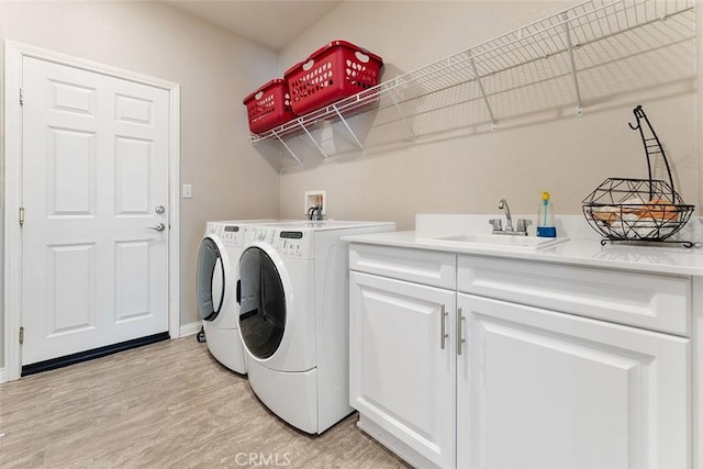 4073 Tamarind Rdg, Lake Elsinore, CA 92530 - laundry room with washer and dryer, light wood-type flooring, and cabinet space