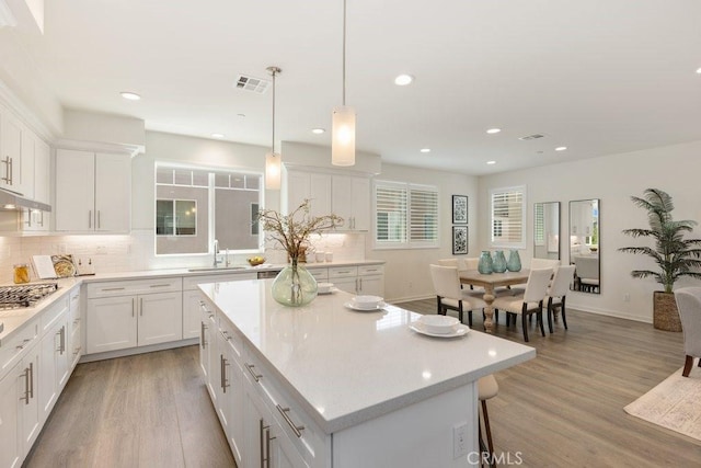 542 Cultivate, Irvine, CA 92618 - kitchen featuring decorative backsplash, white cabinetry, light wood-type flooring, recessed lighting, and a kitchen island