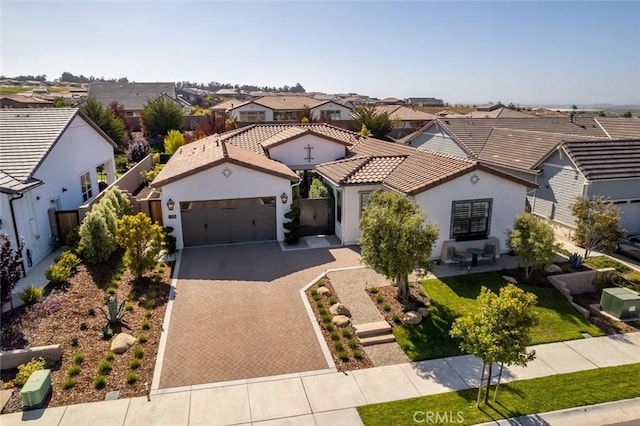 1115 Myles Ln, Nipomo, CA 93444 - mediterranean / spanish house featuring a residential view, a garage, decorative driveway, and stucco siding