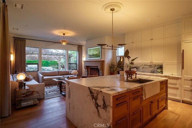 1115 Myles Ln, Nipomo, CA 93444 - kitchen with light wood finished floors, open floor plan, a fireplace, light stone countertops, and white cabinets