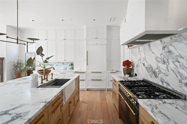 1115 Myles Ln, Nipomo, CA 93444 - kitchen featuring custom exhaust hood, stainless steel stove, backsplash, light wood-style floors, and light stone countertops
